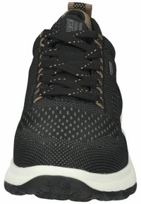 Musthave mustsneaker mustshoe teksitriibudega ülemine osa, kontrastsetest pruunidest paeltest ja valgest tallast. Üksikasjad: perforeeritud muster ja logo detail.