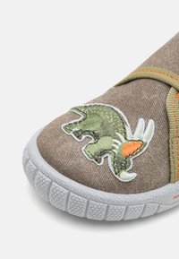 Rjavi tekstilni čevlji z zelenim vezenim motivom dinozavra, gumijastimi podplati z teksturirano oprijemom in oranžno šivano podrobnostjo na strani.