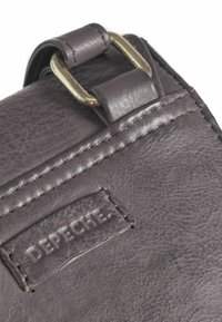Sivá kožená kabelka s textúrovaným povrchom, s mosadznou prackou a prešitými detailmi. Sembossovaným logom s nápisom "DEPECHE."