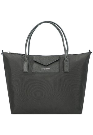 Black tote bag made from textured fabric with dual handles, front pocket, and zip closure. Features subtle branding at the front.