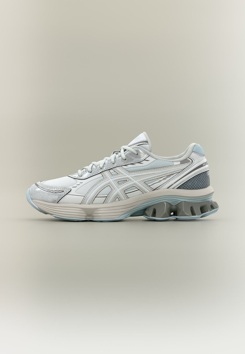 Baltas ir pilkas sportinis bėgimo batelis su raišteliais priekyje, puoštas šoninėmis detalėmis ir unikaliu pado dizainu su paminkštintomis kulno pagalvėlėmis.