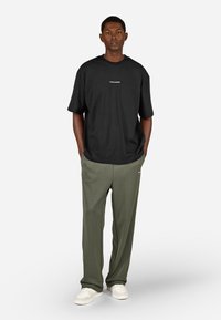 Μαύρο oversized T-shirt με το λογότυπο "PEGADOR" και γκρίζο-πράσινο φαρδύ παντελόνι. Το σύνολο διαθέτει χαλαρή εφαρμογή και μαλακό ύφασμα.