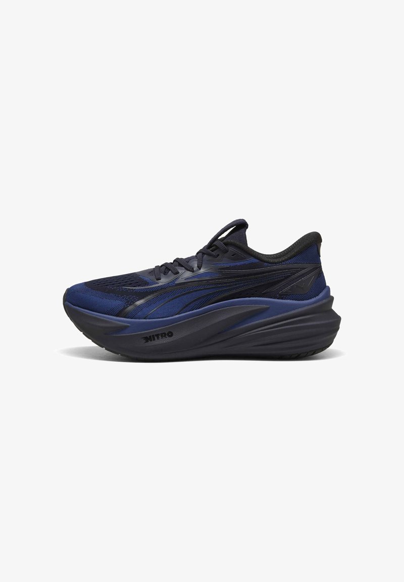 Chaussure de course athlétique bleu foncé et noire avec une semelle épaisse et rembourrée et des lacets noirs, vue de côté sur fond blanc.