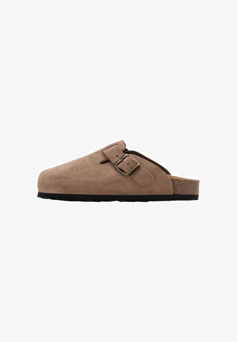 Bruna mockasiner i mocka med korkfotbädd och svart gummiutsida. Har en sidspänne för justerbar passform. Snygg yta.