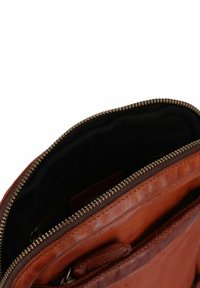 Bruine leren tas, ritssluiting met vergulde hardware, zachte textuur, zwarte stoffen voering, met meerdere binnenzakken voor organisatie.
