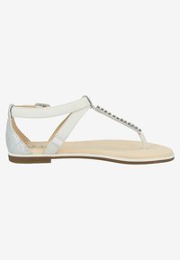 Sandalo piatto bianco con design a T, accentuato da elementi in argento e dettagli borchiati, soletta beige morbida e cinturino posteriore argentato con texture.
