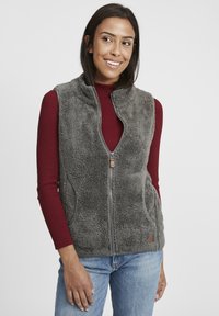 Grauer Fleece-Weste mit durchgehendem Reißverschluss, zwei Seitentaschen und kontrastierenden Abschlüssen. Über einem burgunderfarbenen, gerippten Shirt getragen, lässig präsentiert.