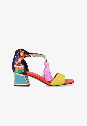 Sandalia de mujer colorida con tacón ancho, tira amarilla en el dedo, borla rosa y patrón decorativo de pájaro con lentejuelas y cuentas en el tacón.