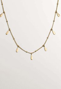 Collar en tono dorado con una cadena delicada, que presenta colgantes en forma de gota y pequeños acentos esféricos, proporcionando un efecto visual texturizado.