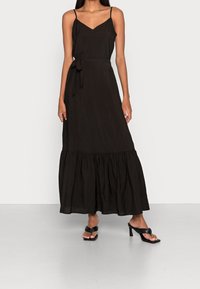 Černé maxi šaty s výstřihem do V, tenkými ramínky a páskem na zavázání v pase. Mají volánkový lem. Vyrobeny z lehkého materiálu.