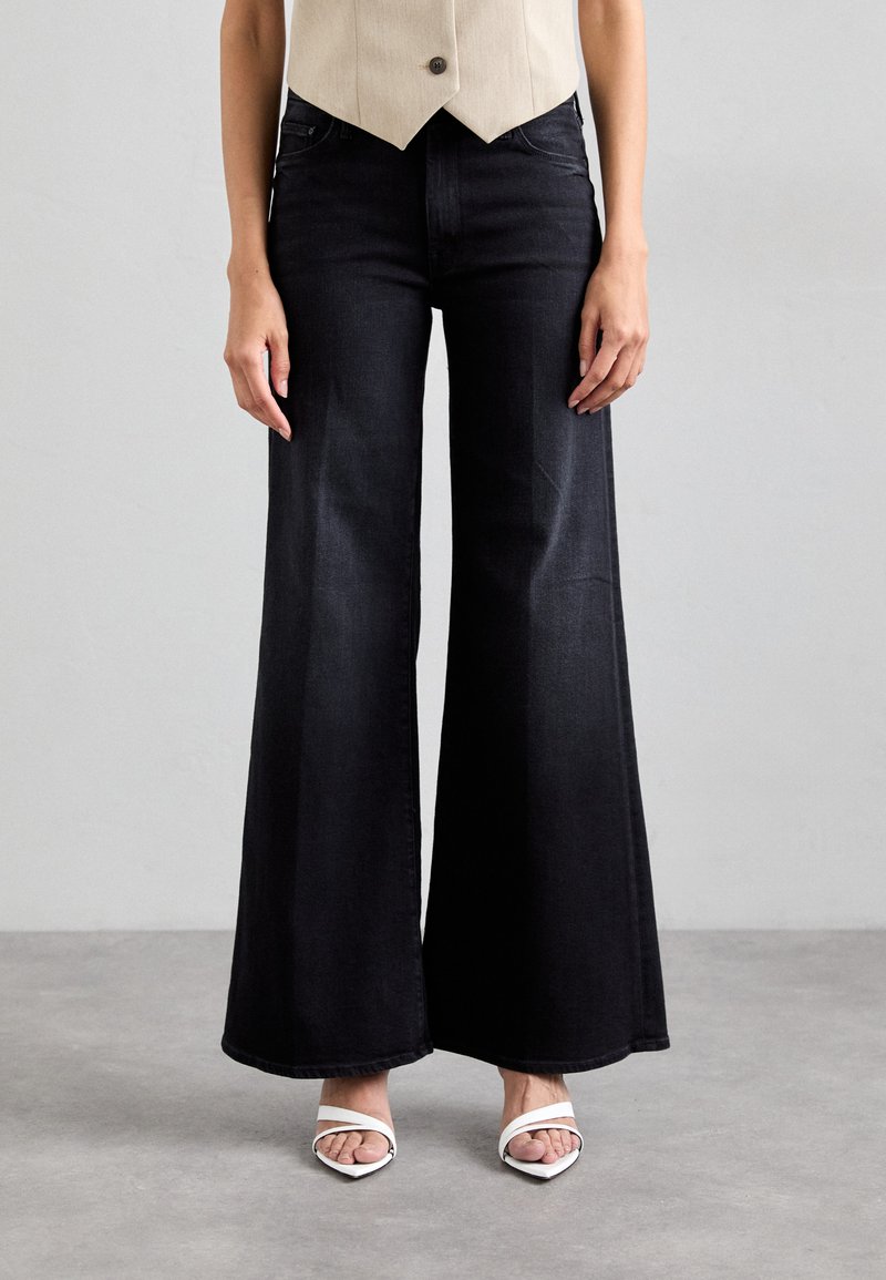 High-waisted black denim flared pants with a smooth texture, featuring a classic five-pocket design and a dark wash finish.