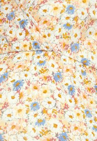 Tecido floral com pequenas margaridas em branco, amarelo e azul sobre um fundo creme claro, com um acabamento suave e texturizado.