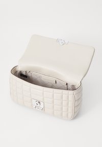 Borsa a tracolla beige trapuntata con chiusura e hardware in argento. L'interno è foderato, presenta una tasca, texture liscia e forma strutturata.
