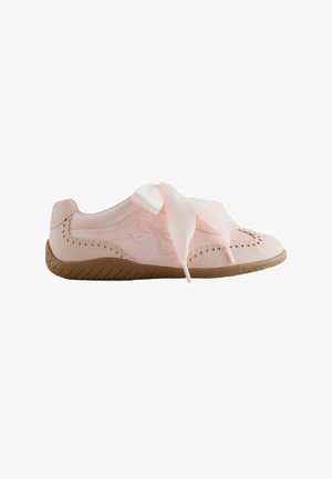 Chaussure décontractée rose clair avec bords festonnés et découpes en forme de cœur, larges lacets en ruban de satin et semelle en caoutchouc marron.