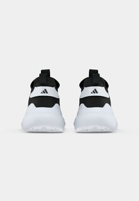 Un paio di scarpe da ginnastica nere e bianche viste da dietro, con suole bianche spesse e il logo Adidas sulle cinghie del tallone.