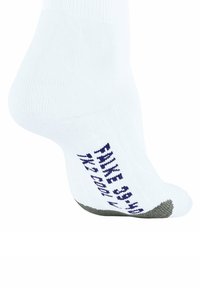Calcetín deportivo blanco con tejido acanalado, talón reforzado y punta gris. El texto en el lateral dice "NIKE 6-12 CAL."