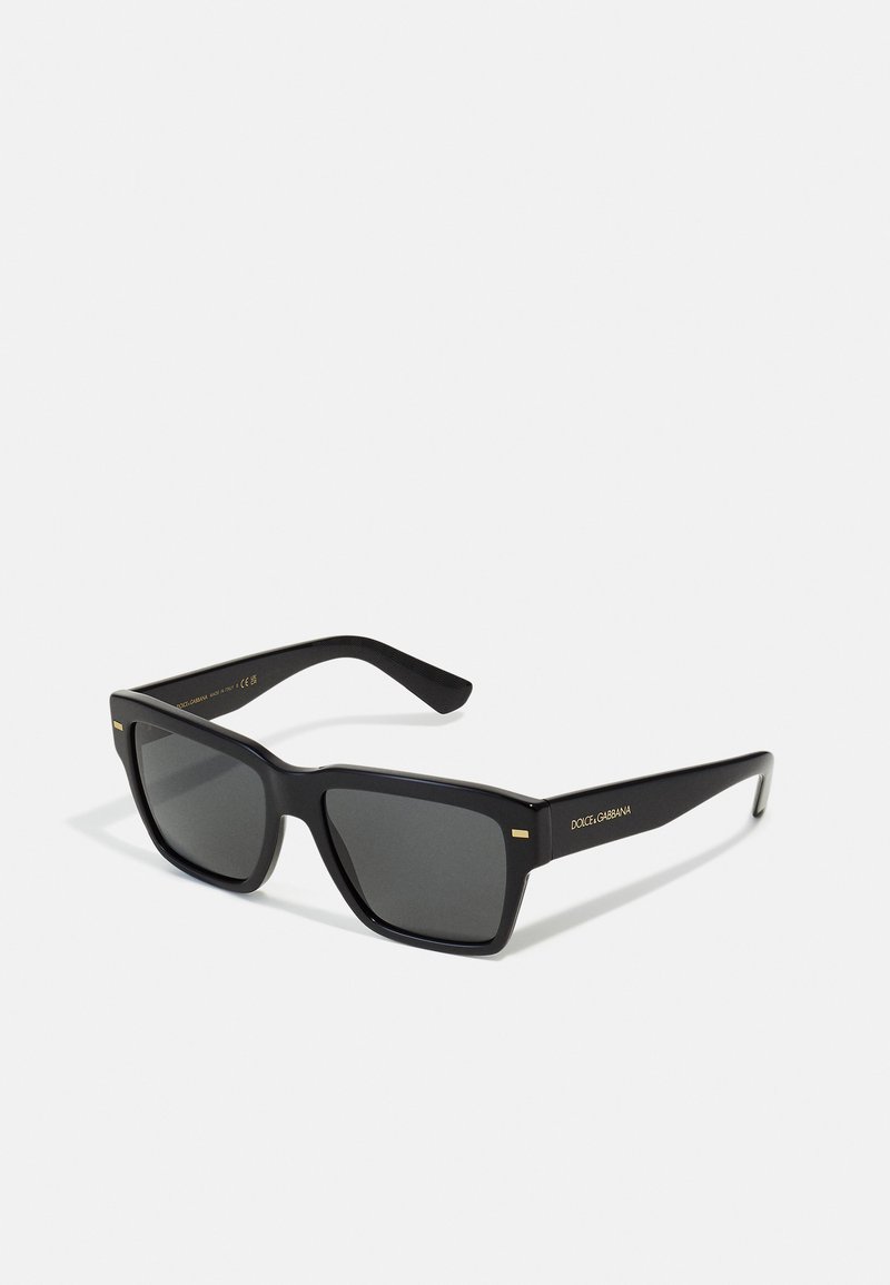 Black rectangular sunglasses with dark lenses, featuring a glossy finish, gold accents on the frames, and a textured inner arm for grip.