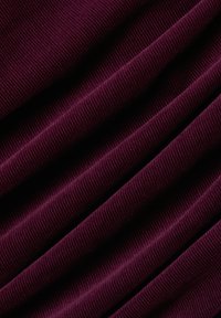 Fioletowa tkanina kordurowa z wyraźnym prążkowaniem i miękką teksturą, wyeksponowana w równomiernie rozmieszczonych fałdach.