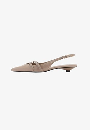 Zapatos slingback de charol color nude con puntera puntiaguda, correas decorativas, herrajes en tono plateado y tacón bajo tipo kitten. Detalles texturizados visibles.