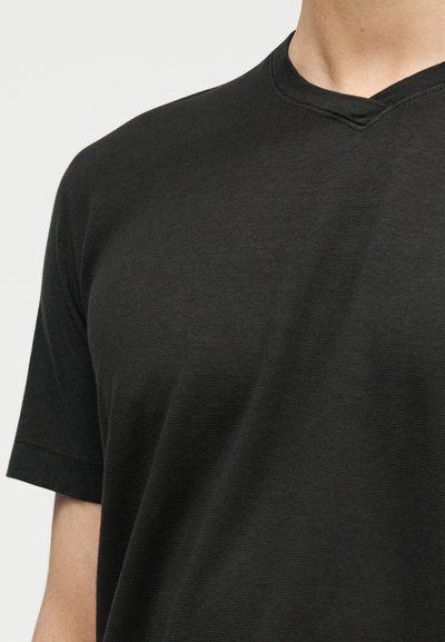 Μαύρο κοντομάνικο μπλουζάκι με V-λαιμόκοψη. Κατασκευασμένο από απαλό, υφασμένο ύφασμα με λεία υφή και διακριτική ραβδίσματα.