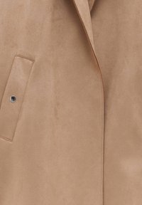 Tan suede blazer with a smooth texture, single chest pocket, visible stitching, and a notched lapel design. Silver snap button accent.