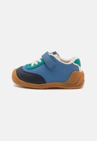Blau- und Grüngemusterte Sneaker aus einer Mischung von textilen und synthetischen Materialien, mit Klettverschluss, weißen Schnürsenkeln und einer Gummisohle.