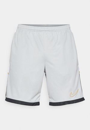Pantalones cortos deportivos grises hechos de tela ligera, con bolsillos laterales, acentos negros y logotipo de Nike en amarillo en la parte delantera.
