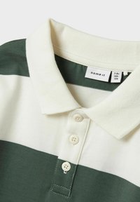 Kraag T-shirt met brede donker groene en witte horizontale strepen, drie witte knopen en een "name it" label met maat 7-8 jaar.