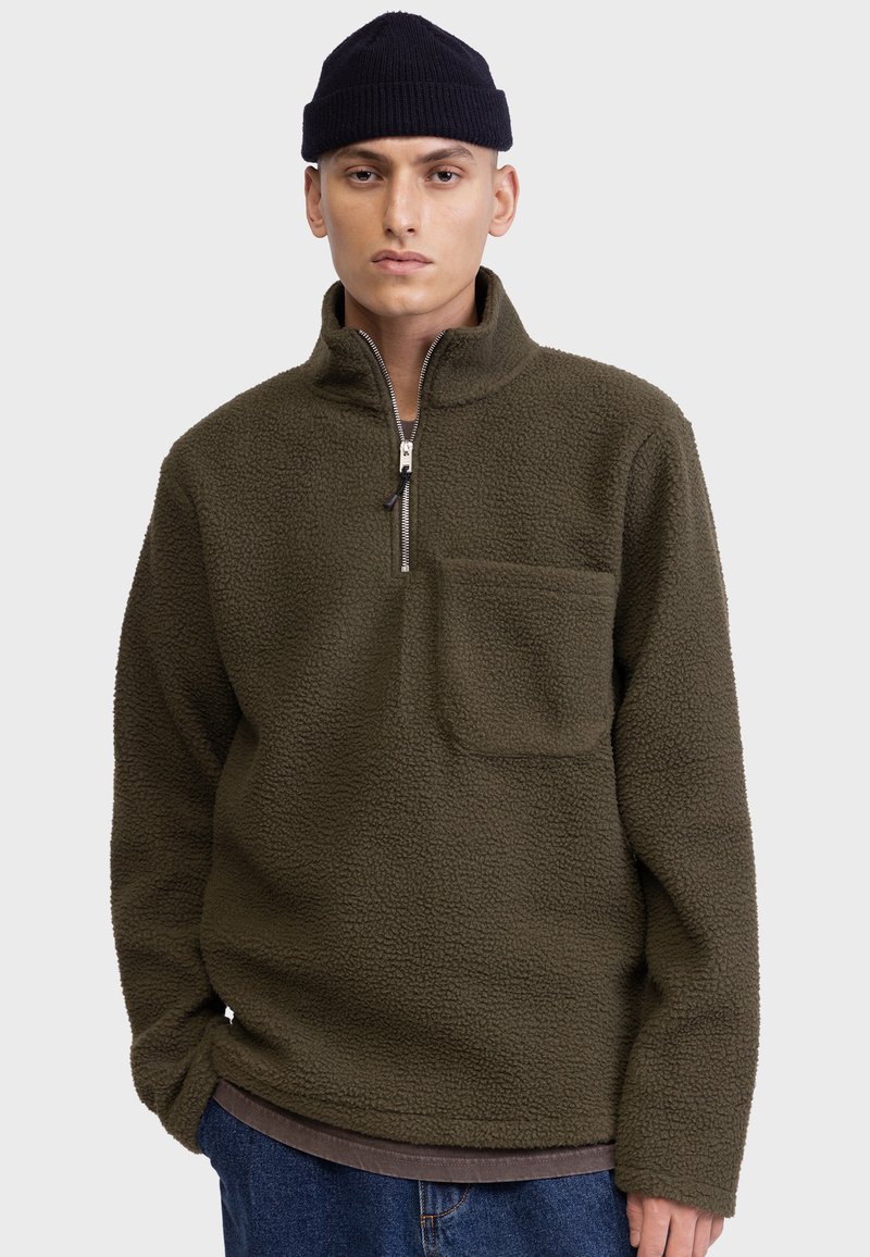 Fleece-Pullover in dunkelolivgrün mit einem Viertel-Reißverschluss vorne und einer Brusttasche. Ausgestattet mit einem weichen, strukturierten Stoff und einer lässigen Passform.