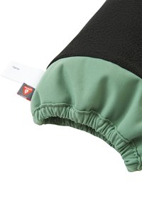 Manica di felpa in pile nera con polsino elastico verde menta. Presenta un'etichetta con nome bianca e un'etichetta rossa del marchio. Texture morbida e design arricciato.