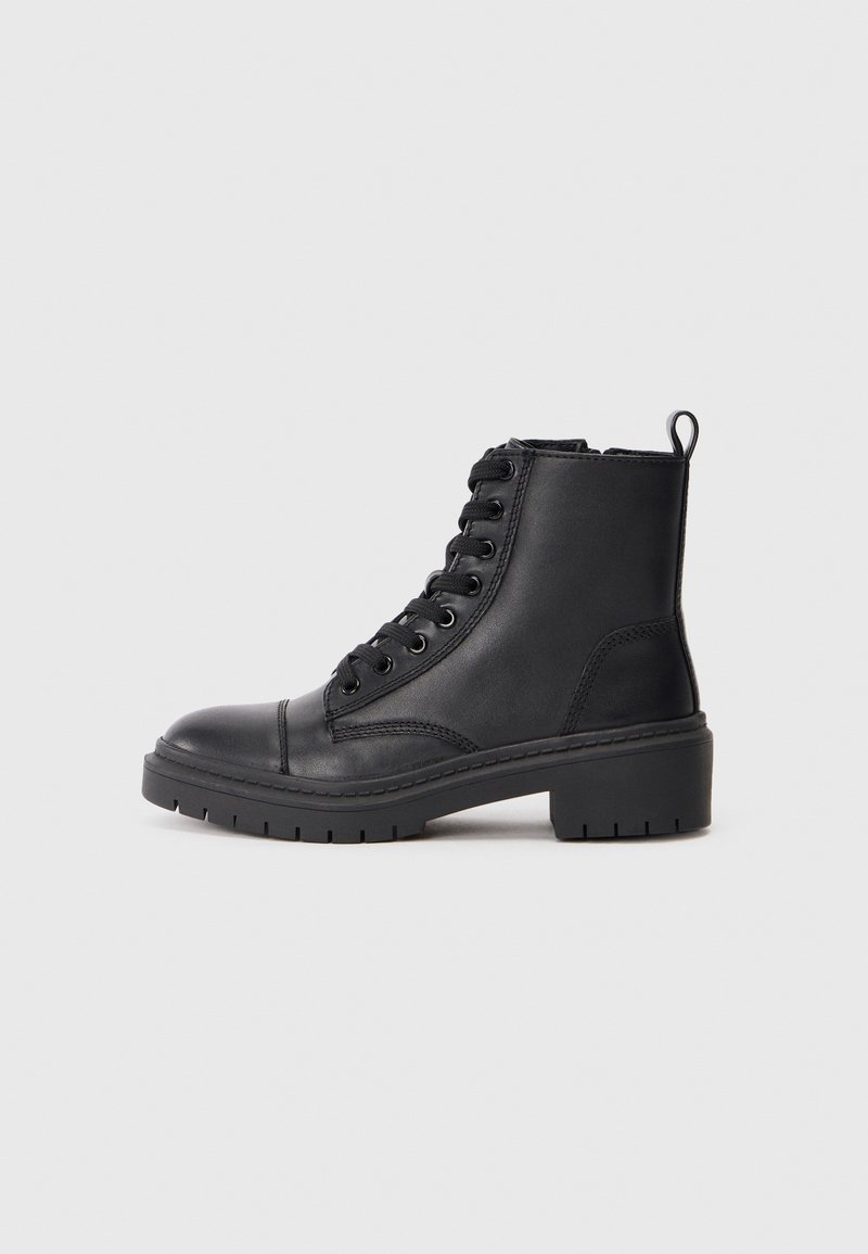 Botas de tobillo de imitación cuero negro con punta redondeada, parte delantera con cordones, lengüeta y suela de goma gruesa con un patrón de textura.