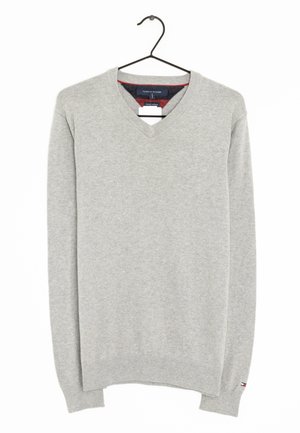 Jasnoszary sweter z długim rękawem i dekoltem w serek na czarnym wieszaku, z subtelnym logo Tommy Hilfiger na lewym mankiecie.