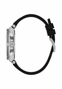 Hodinky s čiernym gumovým remienkom majú obdĺžnikovú striebornú nerezovú korunku, textúrované bočné strany a viaceré tlačidlá na pravej strane.