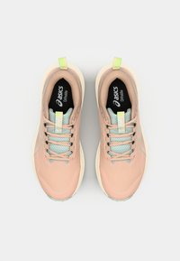 Zapatillas deportivas de color rosa claro con parte superior de malla, cordones en verde menta y suela pálida. Presentan una etiqueta de marca prominente en la lengüeta.