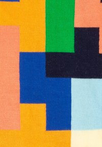 Bunt gemustertes Textil mit geometrischen Blöcken in verschiedenen Blautönen, Orange, Grün, Pink und Schwarz mit einer gerippten Textur.