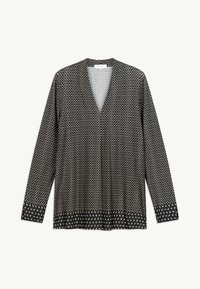 Blouse noire à manches longues avec petit motif carré blanc et pois blancs contrastants sur les poignets et l'ourlet, col en V.
