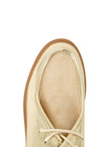 Goldene Schuhe mit einem metallischen Obermaterial und einer glatten Oberfläche sowie einer matten Zehenpartie, ergänzt durch helle Schnürsenkel und eine Gummisohle.