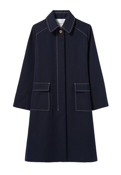 Manteau bleu marine avec col, fermeture à boutons sur le devant, deux poches plaquées et détails de surpiqûres blanches. Présente une silhouette droite et des manches longues.
