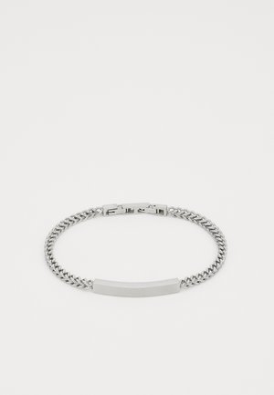 Bracelet en chaîne argentée avec une plaque rectangulaire plate, des maillons entrelacés, une finition polie et un fermoir.