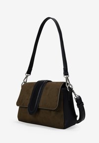 Bolso de mano de gamuza marrón y cuero negro con cierre de solapa, correa ajustable, herrajes plateados y una forma rectangular estructurada.
