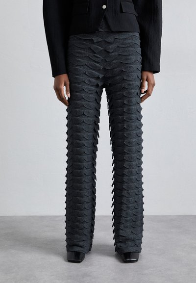 Two-tone pants in charcoal gray with a textured, wavy pattern. Slim fit with a straight leg and a flat waistband. Black square-toe heels.