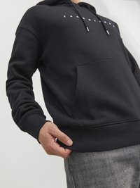 Black hoodie made of soft fabric, featuring a front kangaroo pocket, ribbed cuffs, and a white logo across the chest.
