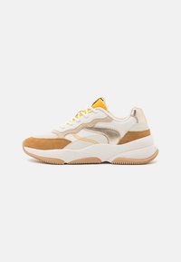 Nízké tenisky v béžové, bílé a hnědé barvě s kovovými zlatými akcenty, bílými tkaničkami a silnou, texturovanou podrážkou.