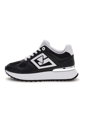 Zwart-witte sneaker met een gestructureerde mesh bovenkant, een soepele leren overlay, een dikke witte tussenzool en een chroomaccent.