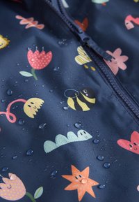 Giacca antipioggia blu navy con motivi floreali e cartoon in colori vivaci, realizzata in materiale impermeabile con gocce d'acqua sulla superficie.