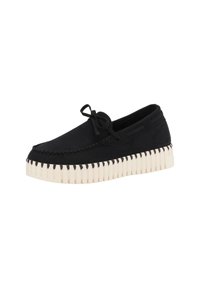 Černé semišové slip-on boty s tlustou bílou žebrovanou podrážkou, zdobené dekorativním šitím a malou mašlí vpředu.