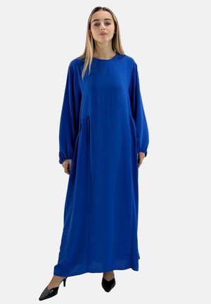 Robe longue, ample, en tissu bleu vif avec des manches longues, des accents froncés sur les côtés, et un col rond.