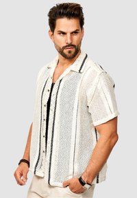 Kurzarm-Hemd mit Knöpfen in Weiß mit schwarzen horizontalen Streifen; leichtes Strickmaterial mit kleinen Maschenöffnungen und klassischem Kragen.