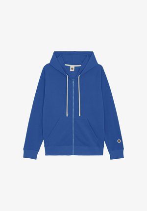 Sweat à capuche bleu avec fermeture éclair, poches avant, cordons de serrage crème, poignets côtelés et un patch circulaire près du poignet gauche.