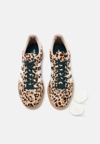 Αθλητικά παπούτσια με μοτίβο λεοπάρδαλης και λευκές ρίγες, με υφασμένο επάνω μέρος, αναπαυτικό πάτο και στρογγυλά λευκά κορδόνια σε φωτεινό φόντο.